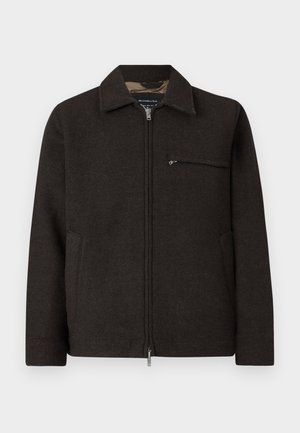 Veste marron foncé en mélange de laine avec une fermeture éclair à l'avant, un col pointu, des poches latérales et une poche poitrine avec fermeture éclair. Fini texturé.