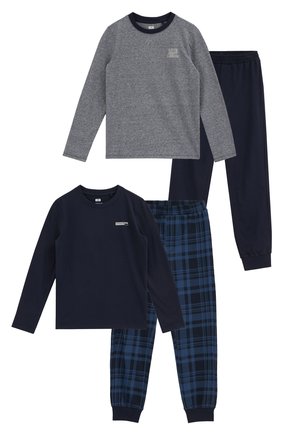 Deux ensembles de hauts à manches longues et pantalons : un haut gris avec un pantalon bleu marine, un haut bleu marine avec un pantalon à carreaux bleu et noir. Les deux ont un petit texte sur la poitrine.