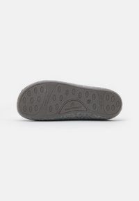 Gray rubber sole with rounded patterns, soft felt upper. Stamped branding "SHEPHERD," indicating a cozy footwear design.