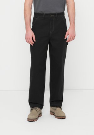Schwarze, gerade geschnittene Hose mit kontrastierenden weißen Nähten, ausgestattet mit einem Knopfverschluss, vorderen Taschen und einer zusätzlichen Seitentasche.