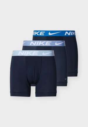 Tre mørkeblå Nike boxer briefs stablet, hver med kontrasterende blå elastiske linninger med hvide Nike-logoer og swoosh-symboler.