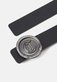 Cintura nera con cinturini lisci, caratterizzata da una fibbia rotonda in argento a forma di serpente che si avvolge attorno a un logo prominente.