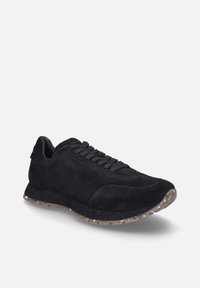 Schwarze Wildleder-Sneaker mit Schnürdesign, gepolstertem Kragen, strukturiertem Profil und einer leichten, gesprenkelten, transluzenten Gummisohle.
