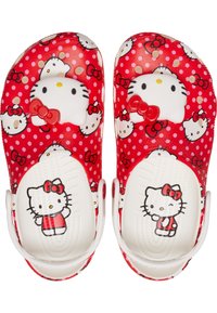 Zuecos rojos de plástico con caras y lazos de Hello Kitty en blanco, con patrones de lunares y correas traseras ajustables.