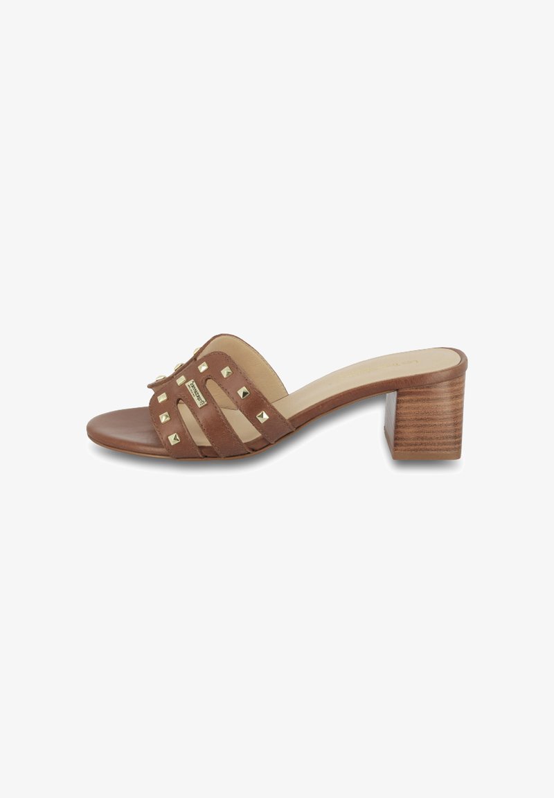 Sandales à talons marron avec un talon bloc, présentant un design de brides croisées ornées de clous métalliques et d'une finition en cuir lisse.