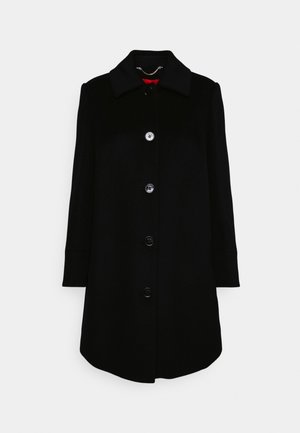 Manteau noir longueur genoux avec manches longues, col et quatre boutons sur le devant, présenté sur un fond clair uni.