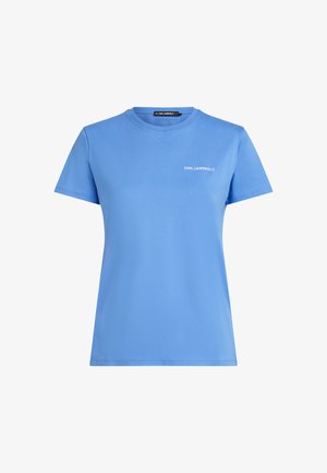 Světle modré bavlněné tričko s kulatým výstřihem a krátkými rukávy, s bílým vyšitým nápisem "KARL LAGERFELD" na hrudi.
