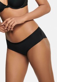 Czarne, gładkie figi bezszwowe o niskim stanie. Wyposażone w starannie wykończoną talię i brak widocznych szwów dla komfortu.