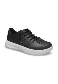 Zapatillas deportivas negras con parte superior perforada, detalles texturizados y suela blanca. Presentan cordones redondos y una suela acolchada para mayor comodidad.