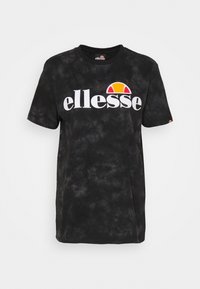 Camiseta de manga corta negra con efecto tie-dye, con un atrevido logo blanco de "ellesse" y un gráfico en semicírculo rojo-naranja en el pecho.