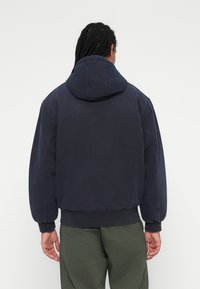 Mørkeblå hætte-sweatshirt lavet af blødt stof, med en cropped design, ribbede ærmer og kant, i en afslappet pasform og minimal syning.