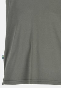 Tessuto grigio con una piccola etichetta cucita con una bandiera svedese blu e gialla vicino all'orlo.