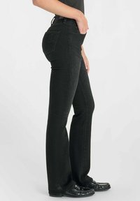 Zwarte denim flared jeans met een aansluitende taille, twee zijzakken en subtiele stiksels. Gestructureerde stof met een gladde afwerking.