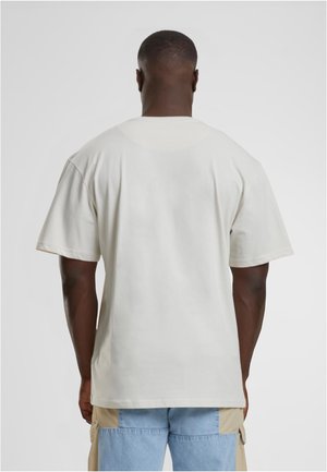 Kortärmad t-shirt med rundad hals i ljusbeige tyg, med avslappnad passform, jämn textur och utan synliga mönster eller accenter.