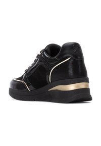 Sneaker nera caratterizzata da un mix di pelle verniciata e suede, con una striscia d'accento dorata sul tallone e dettagli testurizzati sul lato.