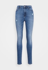 Jeans ajustados de mezclilla azul con ligero desgaste en los muslos, cierre frontal con botón y diseño clásico de cinco bolsillos.
