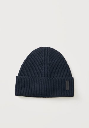 Mørkeblå ribstrikket beanie med opslået kant og et lille rektangulært mærke på kanten.