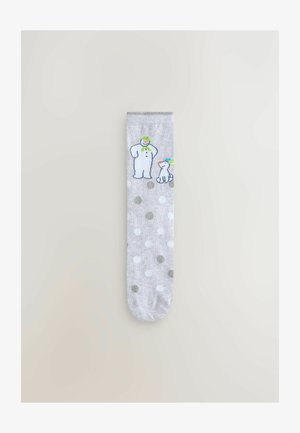 Graue Socke mit weißen und metallischen Punkten, die ein Grafik von einem Schneemann und einem Hund zeigt. Hergestellt aus weichem Stoff mit einer glatten Textur.