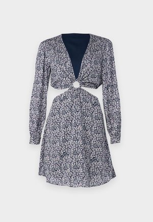 Robe fleurie à manches longues, décolleté en V profond, détail noué à la taille avec un accent circulaire. Fond navy avec des fleurs roses et blanches.