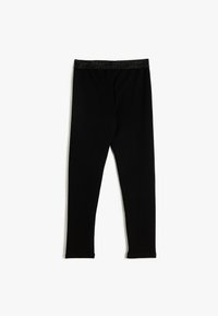 Leggings noirs en tissu texturé avec une ceinture métallique sombre et extensible. Le design est ajusté, se rétrécissant vers les chevilles.