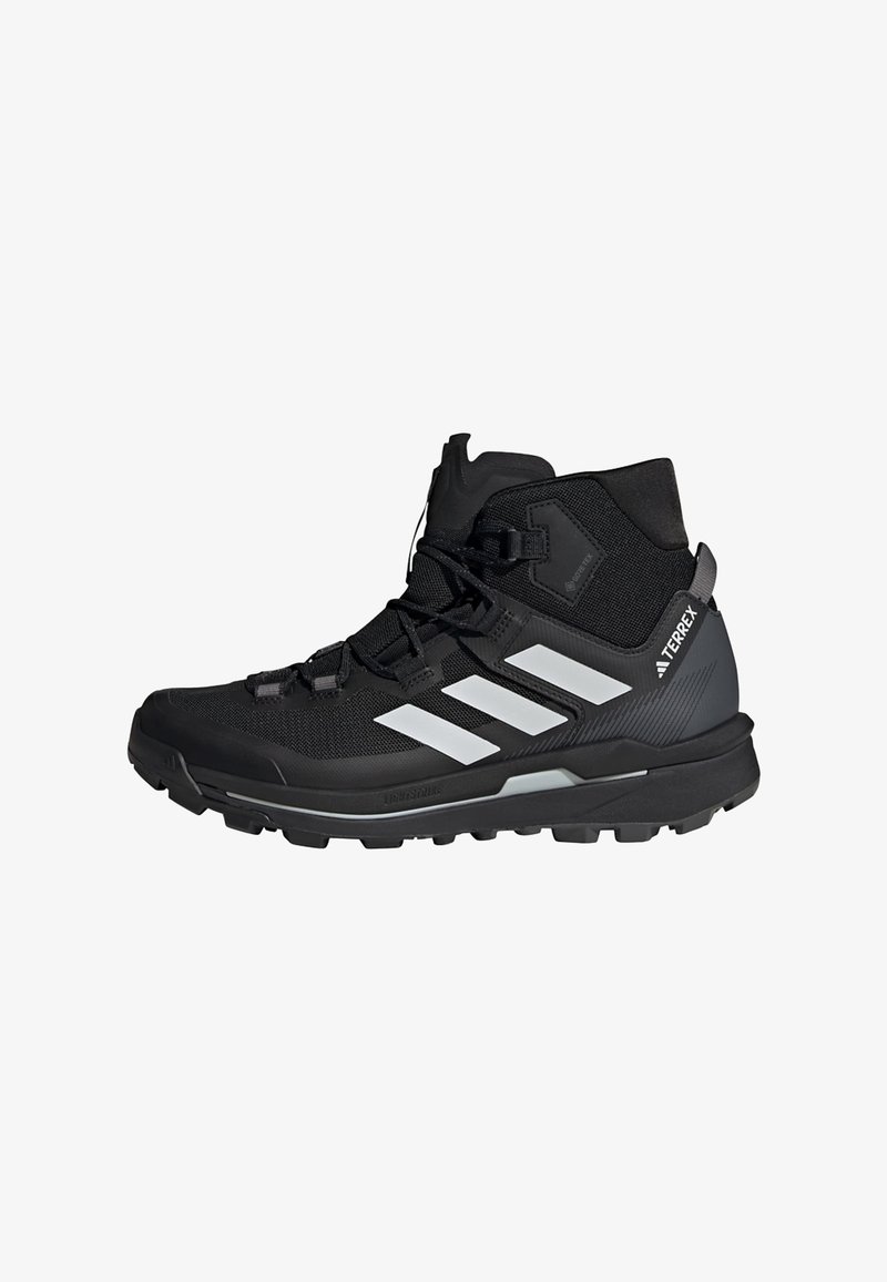 Svart tursko med høy ankel, nettingoverdel, hvite tre striper, teksturert overflate og robust såle for godt grep. Utstyrt med GORE-TEX.