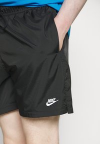 Pantalones cortos negros de Nike con una tela suave y ligera. Cuentan con una cintura elástica, bolsillos laterales y un logo blanco en la parte inferior izquierda.