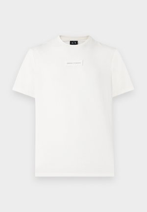 Valge lühikeste varrukatega Armani Exchange t-särk, mille rinnal on väike ristkülikukujuline logo ja must kaeluslabel.