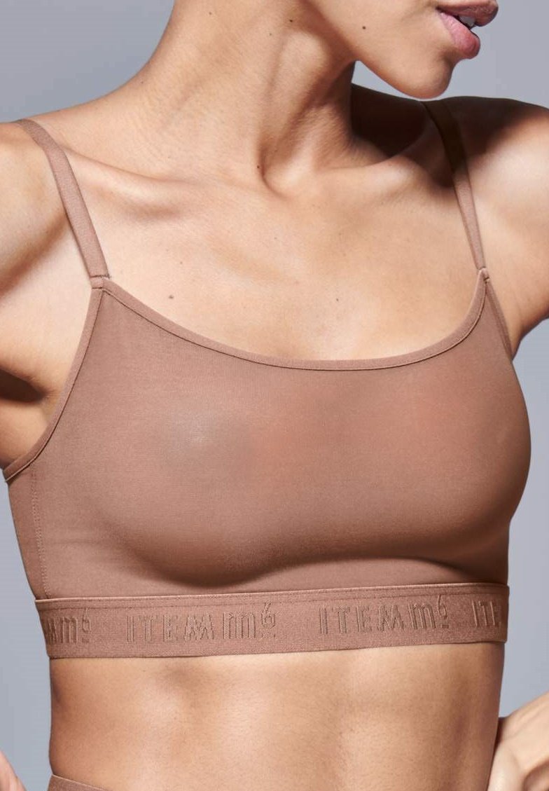 Bralette marrone realizzato in tessuto morbido. Presenta spalline sottili e una banda testurizzata con lettere in rilievo. Design semplice, forma aderente.