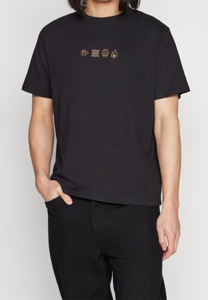 T-shirt noir en coton avec cinq petits motifs graphiques contrastants sur la poitrine dans une teinte plus claire, doté d'un col rond et d'une coupe décontractée.