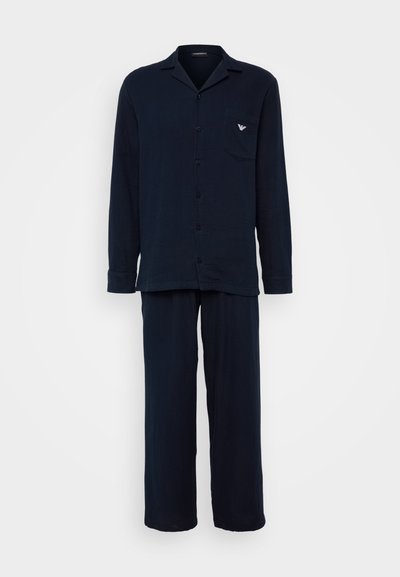 Conjunto de pijama azul-marinho feito de tecido macio. Apresenta uma camisa de botão com colarinho e bolso no peito, acompanhada de calças de corte largo.