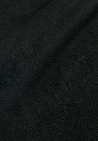 Black fabric with a slightly textured surface, featuring a consistent weave pattern and soft drape, suitable for various applications.
