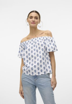 Vit off-the-shoulder blus med blå blommönster, korta puffärmar och lös passform, som kombineras med ljusblå jeans.