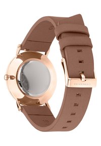 Roségoldene Uhr mit rundem Gehäuse und glattem, reflektierendem Ziffernblatt. Weicher, strukturierter brauner Silikonarmband mit mehreren Größenlöchern.