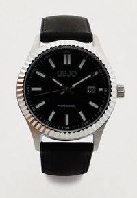 Schwarze analoge Uhr mit Edelstahlgehäuse, strukturiertem Lünettenrand und schwarzem Lederarmband. Verfügt über ein dunkles Zifferblatt mit silbernen Stundenmarkierungen und einem Datumsfenster.