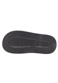 Suela de zapato de goma negra con estrías verticales, forma ligeramente curva y sección central lisa. Incluye logotipo de marca en relieve en la superficie.
