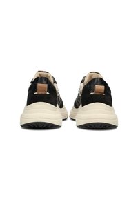Zapatillas negras con un upper texturizado que mezcla materiales, suela de goma crema y acento en cuero marrón en el talón.