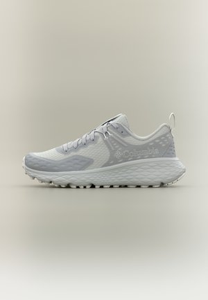 Zapatilla de running Columbia en gris claro y blanco con suela texturizada y parte superior de malla, logo lateral y cierre de cordones, mostrada de perfil sobre un fondo neutro.