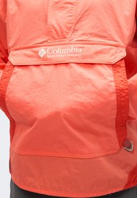 Κόκκινο ελαφρύ μπουφάν με φερμουάρ στο μπροστινό μέρος, επώνυμο λογότυπο και μπροστινή τσέπη. Ύφασμα με ελαφρώς υφή, ορατές ραφές και περιμετρικό τελείωμα.