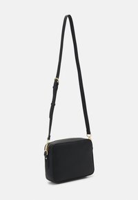 Black textured crossbody bag with a rectangular shape, gold zipper detail, and an adjustable strap. Smooth surface with a minimal design.