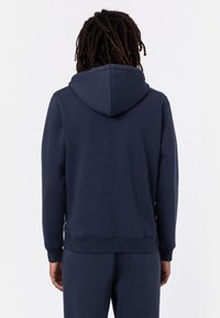 Námořnická modrá mikina s kapucí, měkkou textrurou, dlouhými rukávy a vroubkovanými manžetami, s klokaní kapsou a odpovídajícími tepláky.