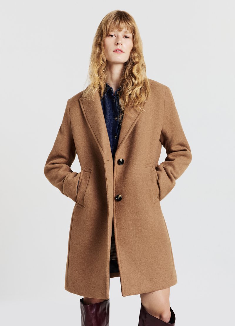 Cappotto in misto lana marrone con rever a punta, due tasche frontali e tre bottoni, caratterizzato da una texture liscia e una silhouette sagomata.