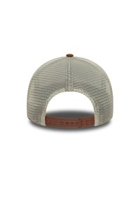 Gorra de malla en tonos beige y crema, con una correa ajustable de goma y un botón de acento marrón. Detallada con un respaldo de malla abierta para ventilación.