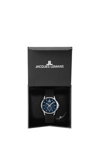 Chronograph-Armbanduhr mit blauem Zifferblatt, Gehäuse in Silberoptik und schwarzem Lederarmband, präsentiert in einer schwarzen Box mit Logo und weicher Innenpolsterung.