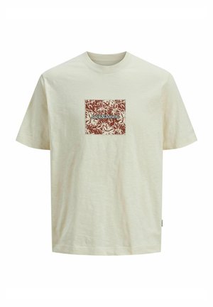 Krémové bavlněné tričko s krátkým rukávem a klasickým střihem, na přední straně čtvercová nášivka se hnědým květinovým vzorem a textem "Jack&Jones" uprostřed.