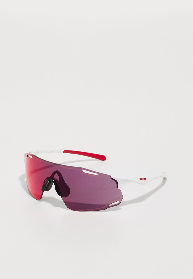 Sunglasses med stora, mörklila linser och en vit ram. Har en röd accent på bågen och ventilationsskärningar på linsen.