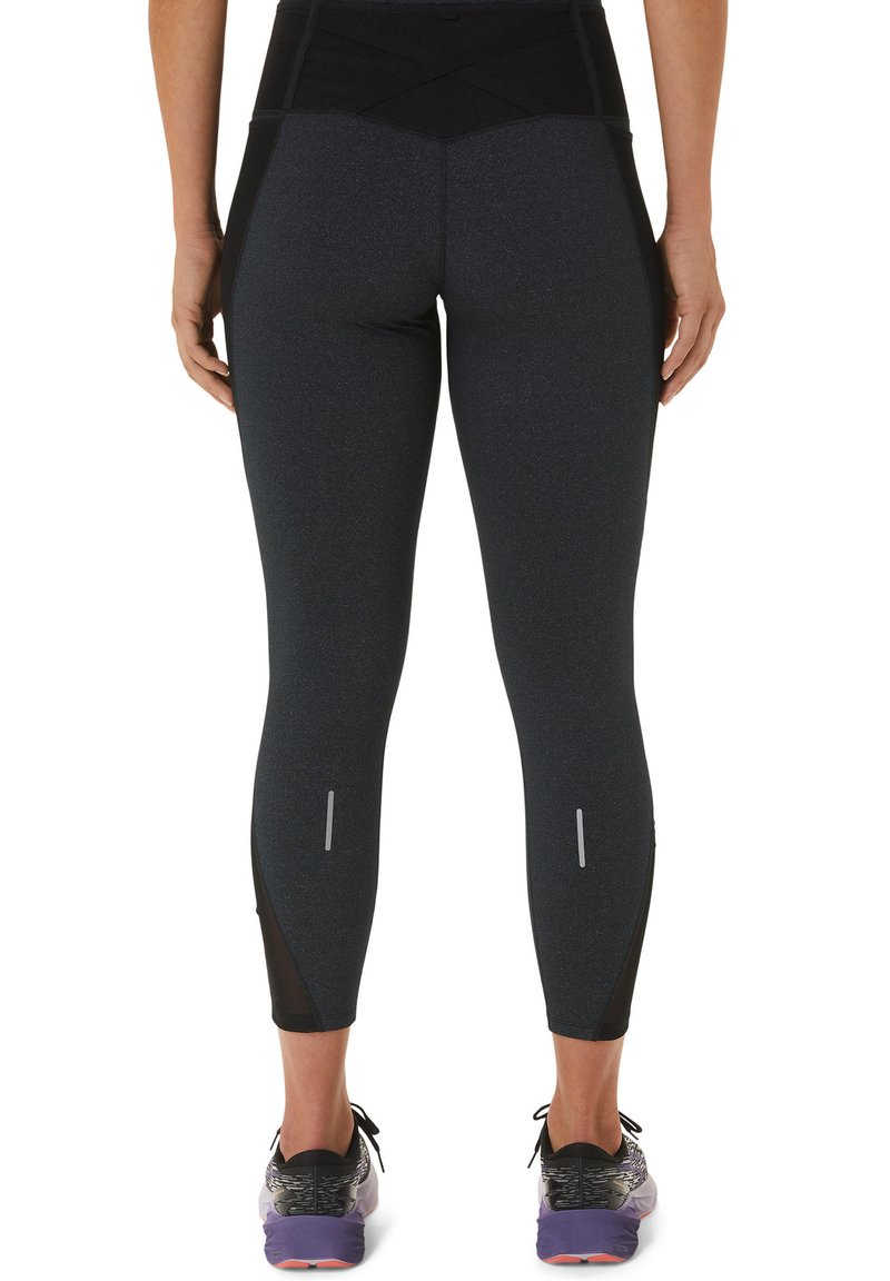 Leggings negros de cintura alta con una textura suave y detalles reflectantes. Presenta una cinturilla negra en contraste y un diseño ceñido.