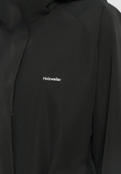 Black jacket made from smooth fabric, features a hood, and a zip closure, with "Holzweiler" logo in white on the front.