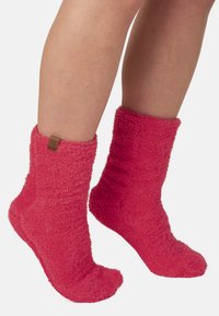 Tova rosa strumpor med en mjuk textur, ribbade mudd, och en liten läderetikett längst upp. Ankelhöjd, utformade för värme och komfort.