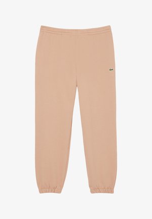 Pantaloni della tuta color pesca con polsini e vita elastici, caratterizzati da un piccolo logo verde Lacoste sulla coscia sinistra. Tessuto morbido.