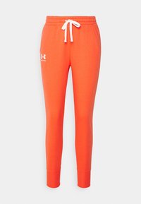 Orange sweatpants med en tapered design, vit dragsko och sidofickor. Har en liten vit logotyp på vänster lår.